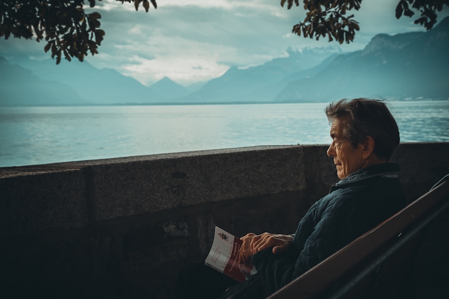 Senhor idoso sereno, contemplando a paisagem tranquila de um lago.
